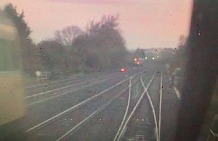 CCTV image from the rear of the train of empty coaches, showing the rail grinding train, travelling towards the junction, on the left