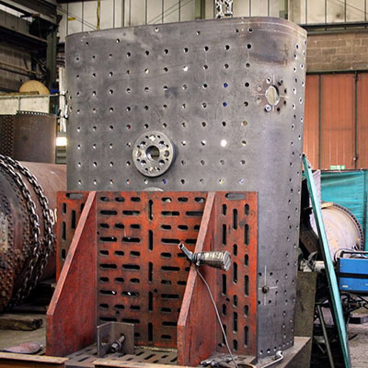 The outer face of the crown sheet clamped on to an angle plate showing one of the safety valve pads and a mudhole.