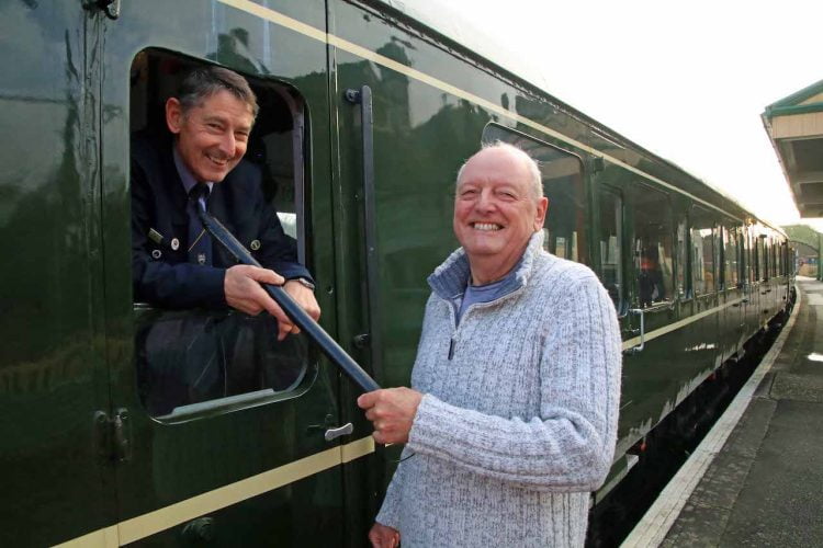 Bob Richards holds the signalling staff tube that he used in 1972, with Peter Frost at Corfe Castle Station on Sat 1st Jan 2022