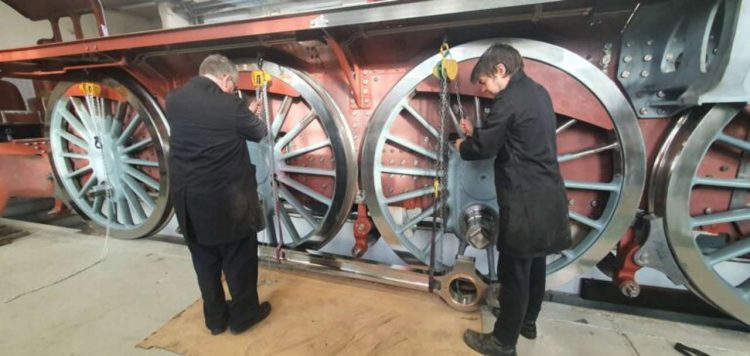 David Elliott and Ed Laxton prepare to lift the first coupling rod to be fitted