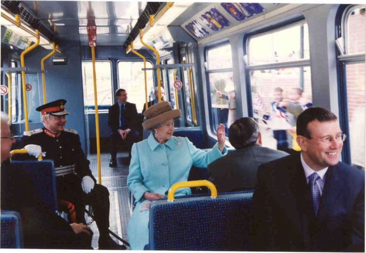 Queen Sitting on Metro Train Waving
