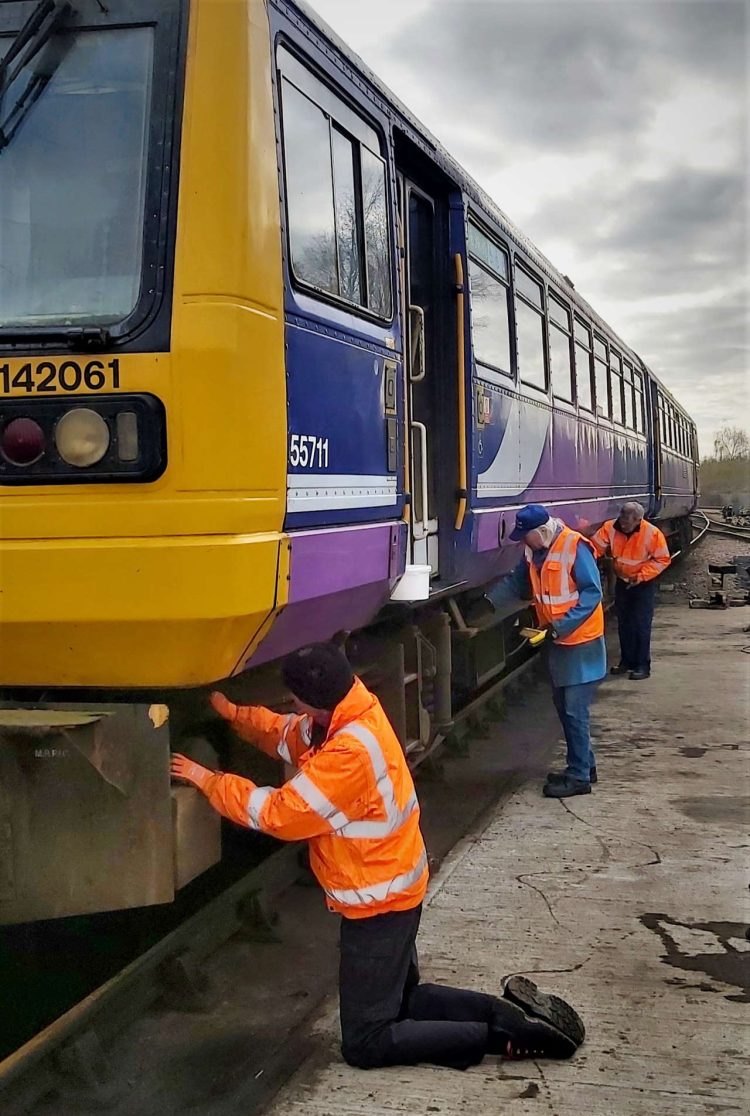 The team painting the underframe of 142061