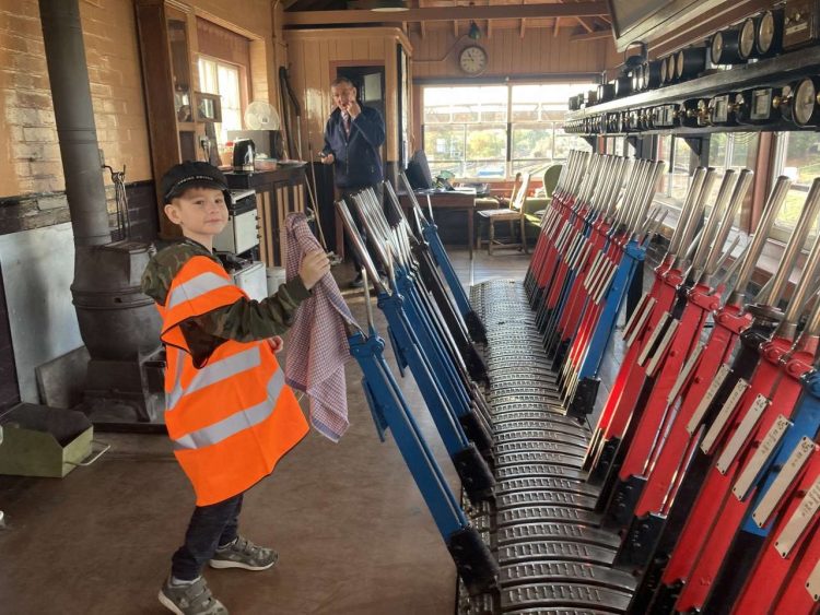 Corey in the signal box, with volunteer signalman Alastair Taylor looking on. Lesley Carr