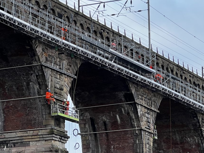 Engineers repairing the Royal Border Bridge using a rope access system