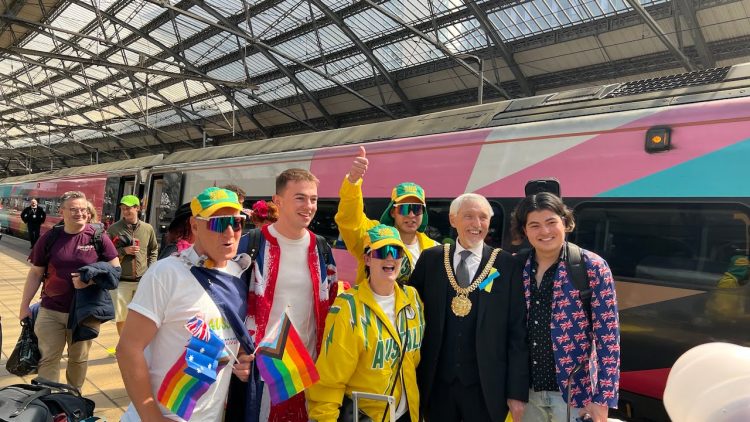 Lord Mayor of Liverpool Cllr Roy Gladden posing with Eurovision fans at Lime Street station