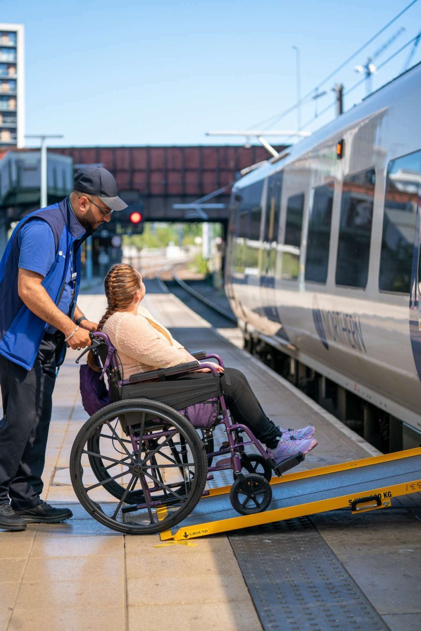 Wheelchair user boarding train with assistance