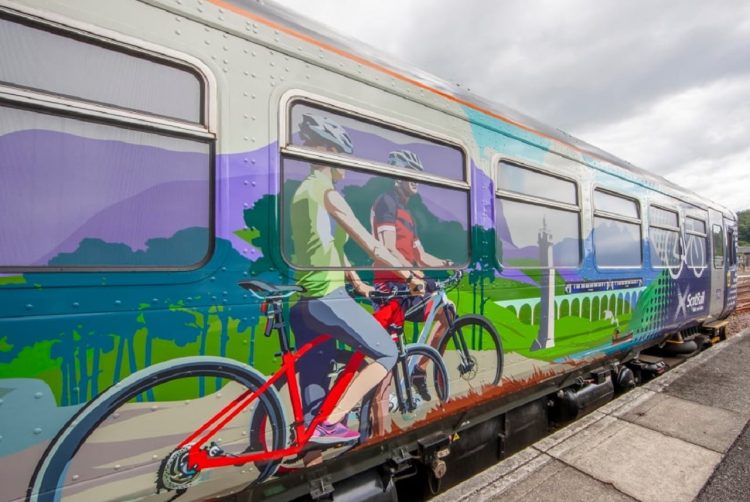 Highland Explorer carriage exterior artwork, showing cyclists in the countryside.