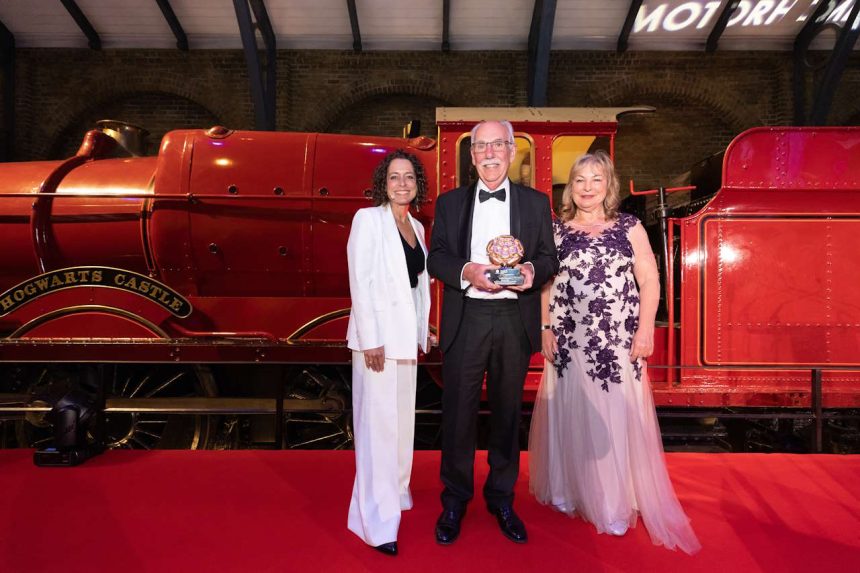 Photo of Gold Award Winner for the Travel Content Award at the VisitEngland Awards for Excellence 2023 - Alicia Miller, The Independent (Alicia Miller, Alexander Layton, VisitEngland Board member Nadine Thompson, Compere Alex Polizzi) - in front the Hogwarts Express on stage