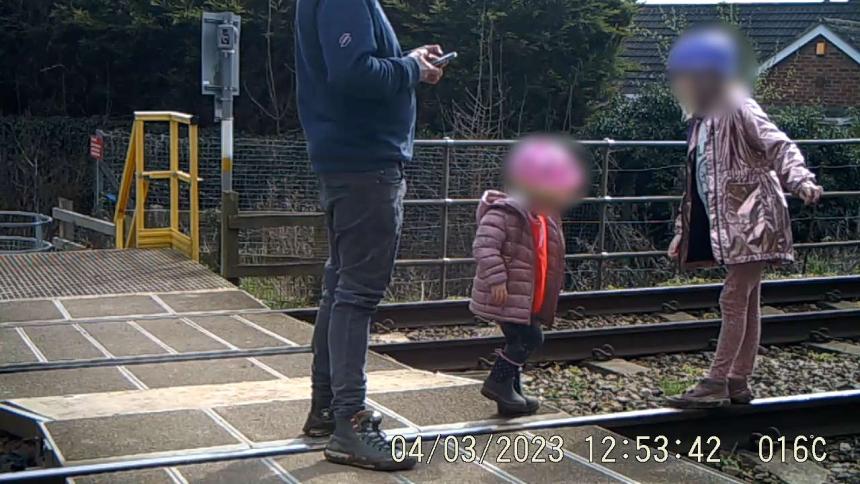 Parent on phone while young children use live tracks as a playground