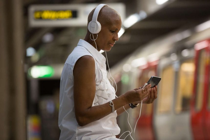 A woman uses her smart phone at Westminster London Underground station.