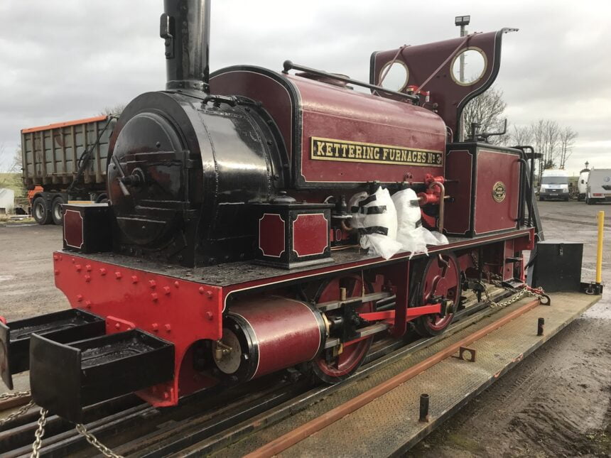 The red livery 0-4-0 locomotive is seen loaded and ready for transporting.