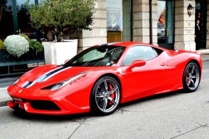 Switzerland, Geneva - red Ferrari parked outside the Four Seasons Hotel des Bergues. // Credit: Roger Smith