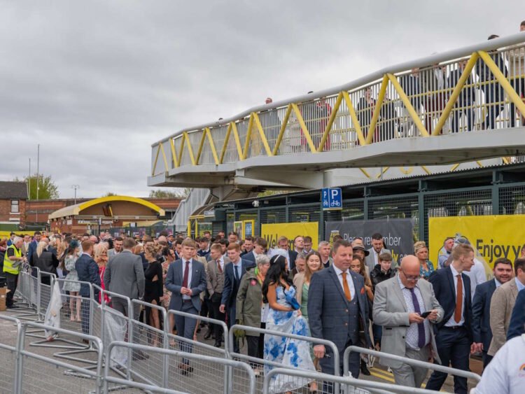 Happy racegoers at Aintree station going home. // Credit: Merseyrail 