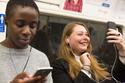 Customers using mobile phones on Tube train. // Credit: Transport for London