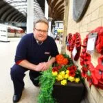 LNER's Paul Simpson poses with flowers and a poppy wreath at York station.