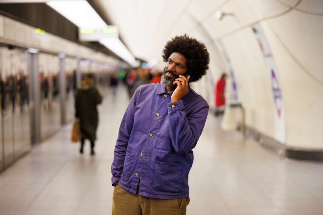 Customer using mobile phone on an Elizabeth line platform. // Credit: Transport for London